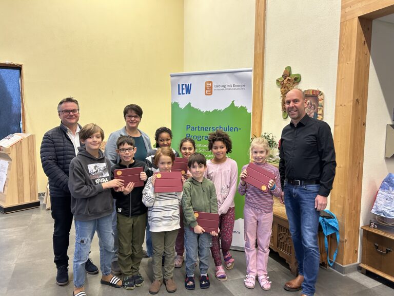 Eine Gruppe von Schüler:innen halten stolz Tablet-Computer in der hand